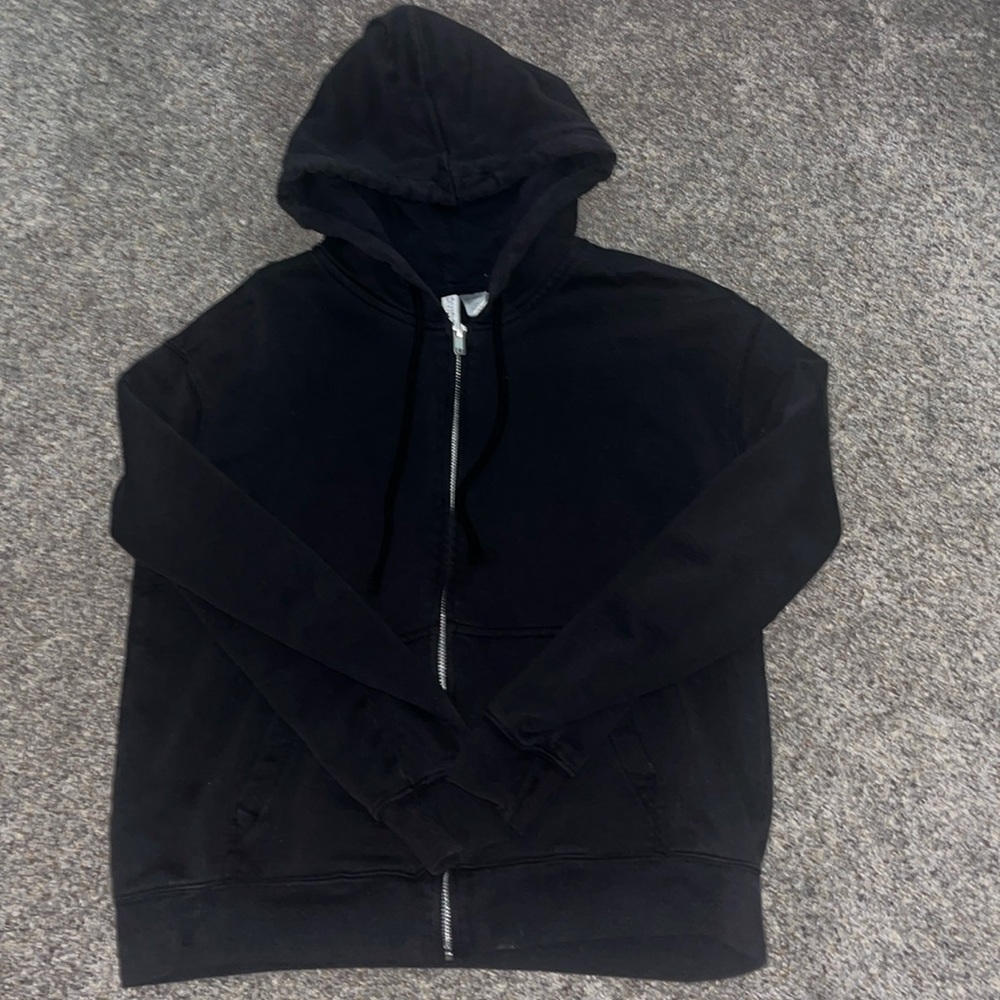 It is a black zip up hoodie made from cotton got from H&M